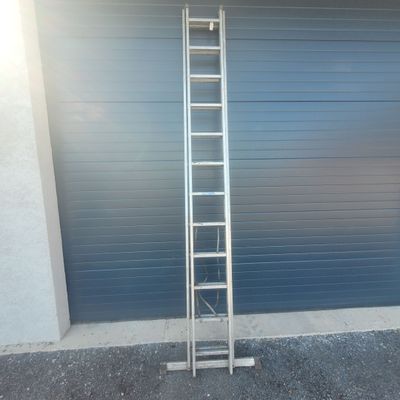 a ladder leaning against a garage door in front of a garage door