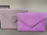 three different colored envelopes sitting next to each other on a table