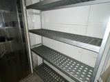 a metal shelf in the middle of a kitchen