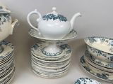 many plates and cups and a teapot on the table