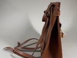 brown leather handbag on a white background with a strap