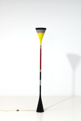 lampe sur pied en forme de cône, avec un pied rouge, jaune et noir