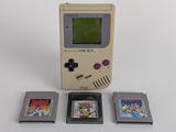 a game boy and three game cartridges next to each other