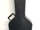 an empty guitar case sitting against a wall with a white background