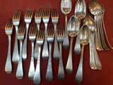 a lot of silver spoons and forks on a table