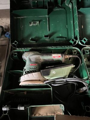 une boîte verte contenant des outils, posée sur le sol