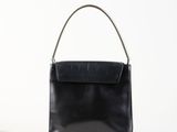 un sac à main en cuir noir sur fond blanc