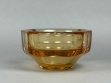 a yellow glass bowl sitting on a white surface