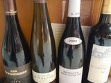 several bottles of wine are lined up on a wooden table