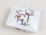 a small white box with a bird and flowers on it