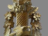 a gold bird sitting on a table with a wreath around it