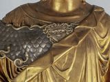 a gold statue of a man with a crown on his head
