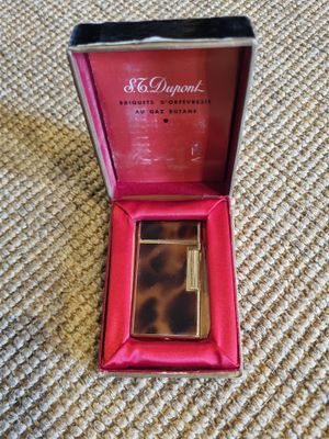 a close up of a box with a lighter in it on a carpet