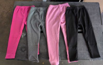 trois paires de pantalons roses et noirs posées sur une table