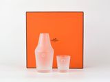 an orange box with two glasses and a bottle on a table