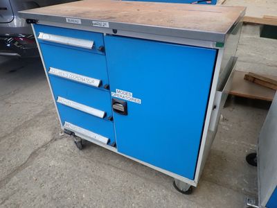 une armoire bleue à tiroirs montée sur roulettes dans un garage