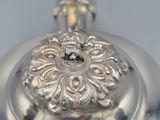 an antique silver teapot with a lid on a table