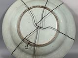 a white plate with a wire around it on a table