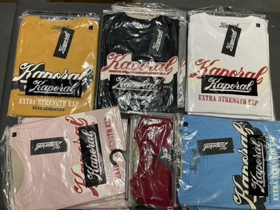 several t - shirts are wrapped in plastic bags on a table