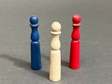 three different colored wooden pawns on a gray surface