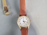 a watch sitting on a table next to a pair of shoes