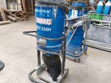 a blue machine that is on a cart in a warehouse