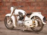 a white motorcycle that is parked in front of a brick wall