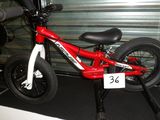 un vélo rouge et blanc garé devant la porte d'un garage