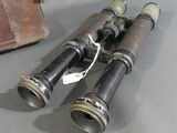 two binoculars sitting on a table next to a leather case