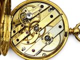 a close up of a pocket watch on a white surface