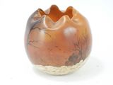 a small vase with a painting on it on a white surface