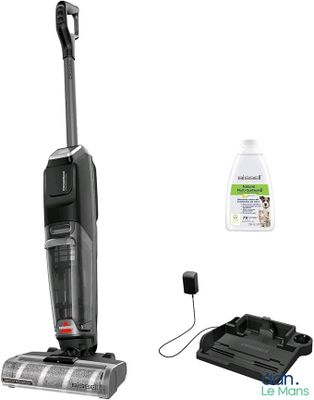 une photo en noir et blanc représentant un aspirateur et un flacon de produit nettoyant