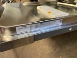 a silver dishwasher sitting on a counter in a kitchen