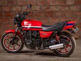 a red motorcycle that is parked in front of a brick wall