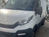 La camionnette blanche est garée à côté d'un cône de signalisation sur le parking.