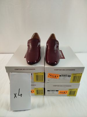deux boîtes de chaussures sont empilées l'une sur l'autre sur une surface blanche