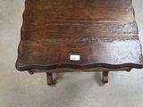 a small wooden table with a label on it