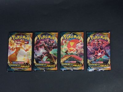 trois paquets de cartes à collectionner Pokémon posés sur une table