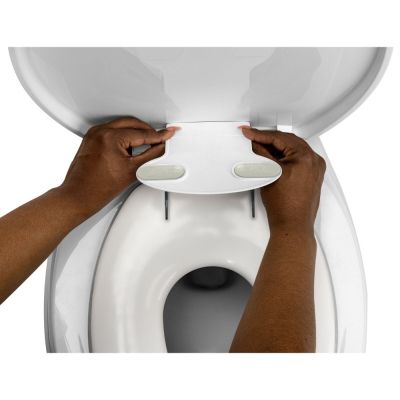 une personne qui tient le couvercle des toilettes