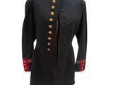 a black military coat with red buttons on a mannequin stand