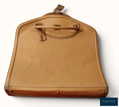un sac beige muni d'une anse, accroché à un mur