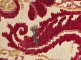 a close up of a red and beige bag on a person ' s lap