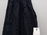 a black dress hanging on a hanger next to a white wall