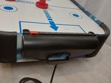 a table with a air hockey board and a game controller