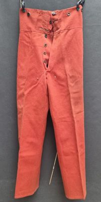 un pantalon orange suspendu à une corde à linge