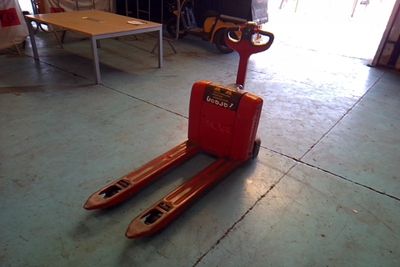 a red forklift sitting on the floor in a garage