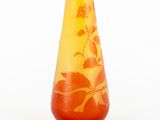 a yellow vase with a red flower on it