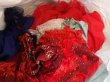a pile of clothes in a plastic bag on a bed