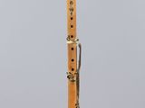 a close up of a wooden flute on a clear stand