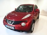 a red nissan juke parked in a white room